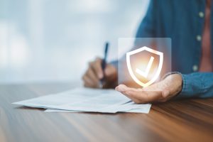 Man with shield with tick in a box signing a health and safety document
